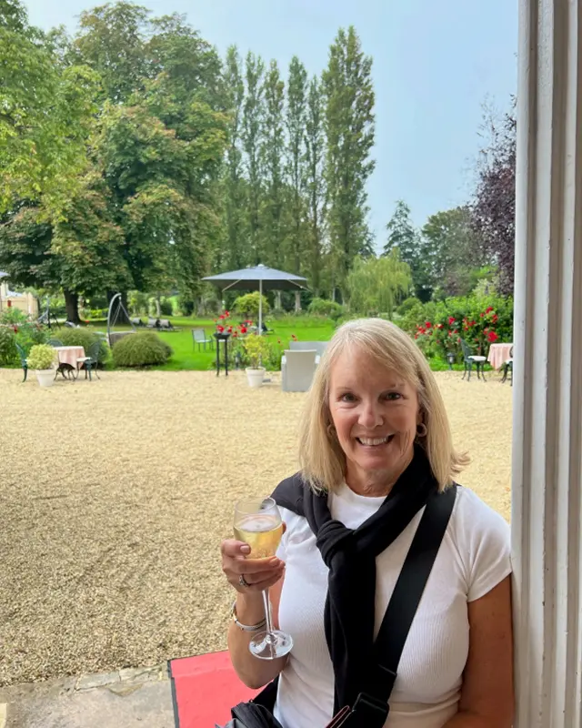 A woman holding a glass of wine in her hand.